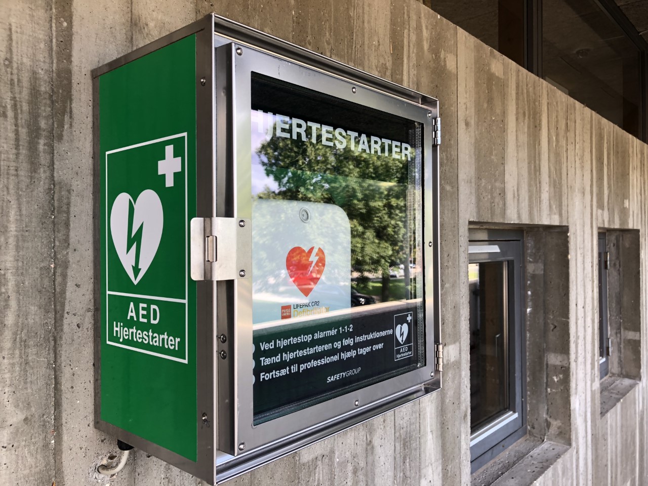 Installed AED cabinet pictured on the SafetyGroup case page.
